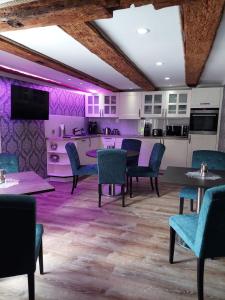 ein Esszimmer mit lila Wänden, Tischen und Stühlen in der Unterkunft AnaCapri Gästehaus Girona in Ueckermünde
