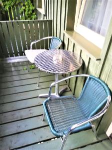 two chairs and a table on a deck at Apartment Christopherhof 11, Grafenwiesen in Grafenwiesen