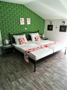 1 dormitorio con 1 cama grande y pared verde en Apartment Christopherhof 11, Grafenwiesen, en Grafenwiesen