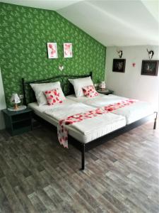 a bedroom with a large bed with a green wall at Apartment Christopherhof 11, Grafenwiesen in Grafenwiesen