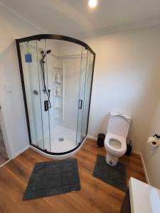 a bathroom with a shower with a toilet and mats at Modern 1 bedroom guest house in Upper Hutt