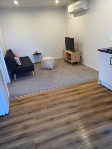 a living room with a couch and a tv at Modern 1 bedroom guest house in Upper Hutt