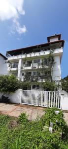a white building with a white fence in front of it at La Lune Fort Kochi in Cochin