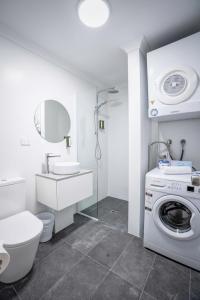 a bathroom with a toilet and a washing machine at Broadwater Resort Como in Perth