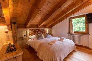 Ciandolada Wellness في Vodo Cadore: غرفة نوم بسرير كبير وسقف خشبي