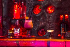 Coral Guest House في ابزور: وجود مشروب على طاولة مع أضواء حمراء