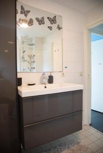 ein Bad mit einem Waschbecken und einem Spiegel in der Unterkunft Beautiful family house 5 min away from Amsterdam in Badhoevedorp