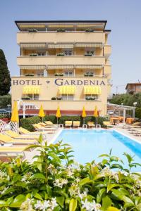 un hôtel avec une piscine en face d'un bâtiment dans l'établissement Hotel GARDENIA & Villa CHARME Adults Friendly 10Plus, à Bardolino
