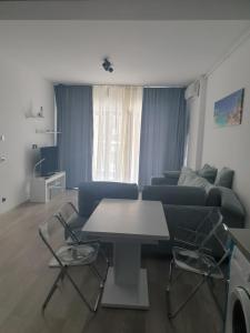 ein Wohnzimmer mit einem Sofa, einem Tisch und Stühlen in der Unterkunft Blue apartament in Mamaia
