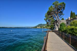 drewniany chodnik nad dużym zbiornikiem wody w obiekcie Taverna Affittacamere w mieście Gardone Riviera