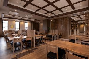 uma sala de jantar com mesas e cadeiras de madeira em Hotel Route-Inn Yonago em Yonago