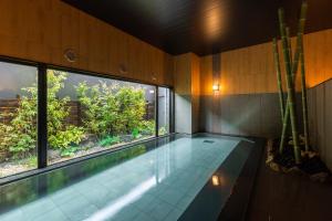 a swimming pool in a room with a large window at Hotel Route-Inn Yonago in Yonago