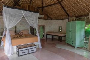La Joya Biu Biu Resort في جيمباران: غرفة نوم بسرير ومكتب في غرفة