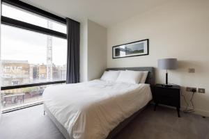 Premium Apartment near Liverpool Street Station في لندن: غرفة نوم بسرير ابيض ونافذة كبيرة