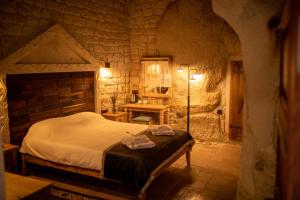 a bedroom with a bed in a stone room at Pome Granate Cave Hotel in Nevşehir