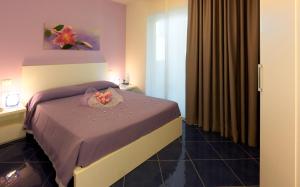 a bedroom with a bed with a bowl of flowers on it at Aurea Hotel in Tortoreto Lido +34 photos