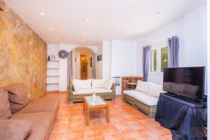 a living room with couches and a flat screen tv at Villa Sol in Cala Figuera