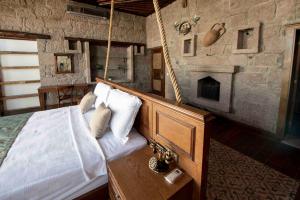 een slaapkamer met een bed en een open haard bij Assos Dionysos Special Class Hotel Adults Only 12 years in Behramkale