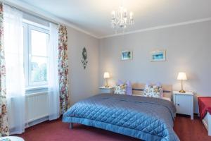 a bedroom with a blue bed and a window at Genesungsort Landhaus Dammert in Oppach