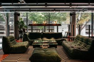 a living room with leather couches and a table at Superbude Wien Prater in Vienna