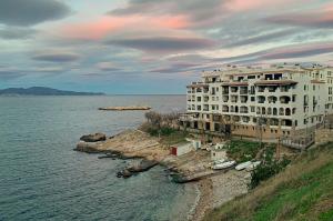 um grande edifício branco na costa de uma massa de água em Apartament galan1966 em L'Escala