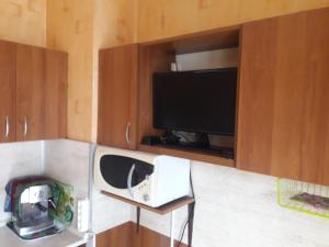 a living room with a tv and a tvictericter at Удобство in Burgas City
