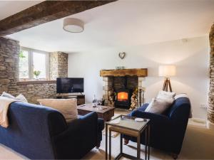 a living room with two blue couches and a fireplace at Field View in Cirencester