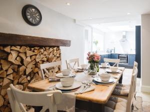 a dining room with a wooden table and a clock on the wall at Field View in Cirencester