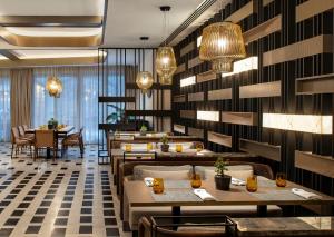a restaurant with tables and chairs and chandeliers at Radisson Collection Hotel, Bodrum in Akyarlar