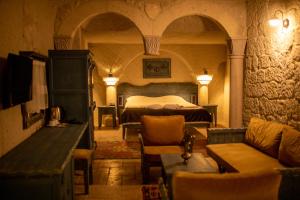 a bedroom with a bed and a couch in a room at Pome Granate Cave Hotel in Nevşehir