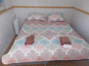 a bed with two pairs of shoes on it at Lilla Stugan, Sjötorp in Sjötorp