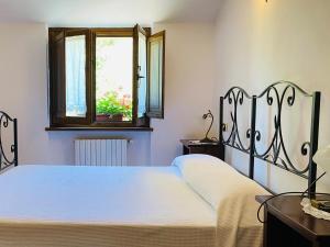 Schlafzimmer mit einem Bett und einem Fenster in der Unterkunft Locanda Cacio Re in Vallo di Nera