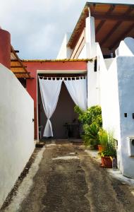 un garaje con una cortina blanca en la puerta en Casa da Vela, en Rinella