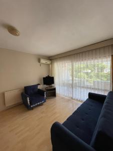 a living room with a blue couch and a television at EVİM APART HOTEL in Termal