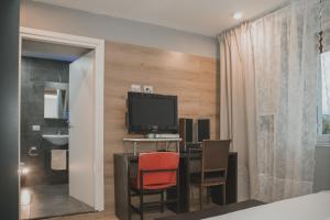 a room with a desk with a television and chairs at Il Perale in Caselle in Pittari