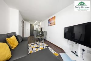 a living room with a couch and a flat screen tv at By NEC and Airport- 5 percent off weekly and 10 percent off monthly bookings-1 Bedroom Apartment at Telly Homes Limited Birmingham - Free WiFi, Aster unit in Birmingham