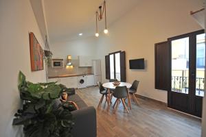 Palacete Centro estilo Luxe في خيريز دي لا فرونتيرا: غرفة معيشة مع طاولة وكراسي ومطبخ