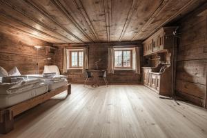 um quarto com uma cama e uma escrivaninha em Hotel Weiss Kreuz em Splügen
