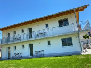 a white building with chairs on the balcony at Boardinghouse37 in Schwarzach