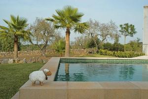 a stuffed sheep standing next to a swimming pool at Son Paparra in Montuiri