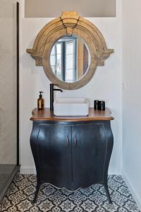 La salle de bains est pourvue d'une coiffeuse noire et d'un miroir. dans l'établissement Libertitu, à Bayonne