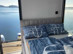 Dormitorio con cama y vistas al agua en Hausboot La Mesa, en Lychen