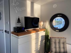 TV de pantalla plana en la parte superior de un armario en Hausboot La Mesa, en Lychen