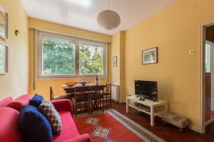 uma sala de estar com um sofá vermelho e uma mesa em Pasteleira Relaxing Apartment em Porto