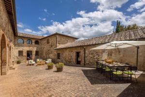 an outdoor patio with a table and an umbrella at Villa La Corte Di Campalli in Castellina in Chianti