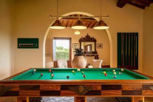 a room with a pool table with balls on it at Villa La Corte Di Campalli in Castellina in Chianti