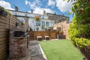 a garden with a barbecue in a house at Harper’s Cottage, Fence, Lancashire in Brierfield