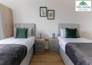 2 bedden in een kamer met groene kussens bij 5 percent off weekly and 20 percent off monthly bookings - Marigold unit at Telly Homes Limited Birmingham City Centre -2 bedroom Apartment, Free WIFI in Birmingham