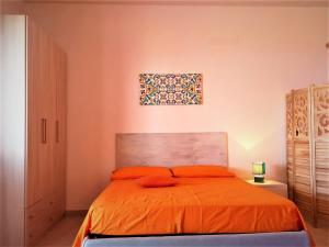a bedroom with a bed with an orange bedspread at La casa blu superior in Lipari