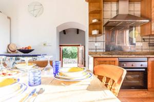 uma cozinha com uma mesa com pratos em Villa Mosteiro, 'The Cosy Corner' em Santa Margalida